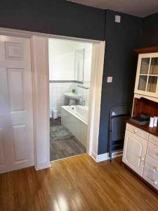 a bathroom with a tub and a toilet and a sink at Netherby Grange Garden Apartment with Sea Views in Llandrillo-yn-Rhôs