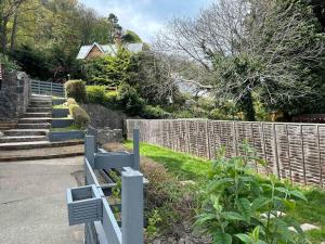 un banc bleu dans une cour à côté d'une clôture dans l'établissement Netherby Grange Garden Apartment with Sea Views, à Llandrillo-yn-Rhôs