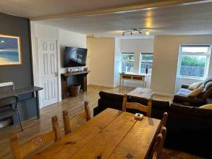 - un salon avec une table en bois et un canapé dans l'établissement Netherby Grange Garden Apartment with Sea Views, à Llandrillo-yn-Rhôs