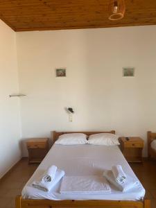 a bedroom with a white bed with two towels on it at Artemis Hotel-MeRaki Restaurant in Frangokastello