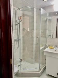 y baño con ducha de cristal y lavabo. en Villa ReTa Hotel & SPA, en Grigoleti