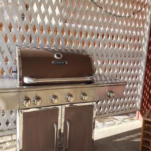 a grill sitting in front of a fence at Global Village Permaculture BnB in Oliver