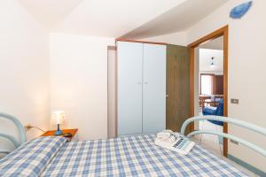 una camera con un letto con copriletto a scacchi blu e bianco di Appartamenti Flavia a Santa Maria Navarrese