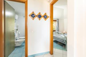 bagno con porta che conduce a una camera da letto di Appartamenti Flavia a Santa Maria Navarrese