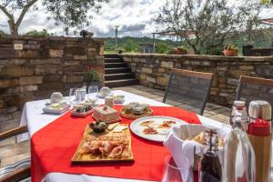 un tavolo con piatti di cibo su una tovaglia rossa di TouristFarm - apartments "RED FAIRYTALE" a Marezige (Marèsego)