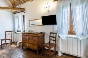 Habitación con vestidor, 2 sillas y TV. en Tenuta Ca' Zen - Cottage Casetta, en Taglio di Po