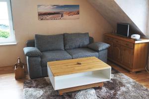 uma sala de estar com um sofá e uma mesa de centro em Ferienwohnung-Daaden em Daaden
