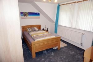 a bedroom with a bed in a room with a window at Ferienwohnung-Daaden in Daaden
