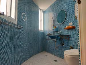 een blauw betegelde badkamer met een toilet en een wastafel bij 棉花雲文旅民宿B&B in Ch'ao-yang