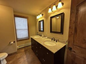 a bathroom with two sinks and a mirror and a toilet at Private Retreat on Working Horse and Cattle Ranch in Salida