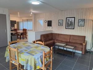 a living room with a table and a couch at Gîte Les Pareurs in La Ferté-Macé