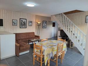 a living room with a table and a couch at Gîte Les Pareurs in La Ferté-Macé