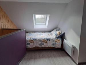 a small bedroom with a bed and a window at Gîte Les Pareurs in La Ferté-Macé