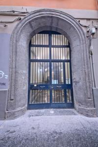 eine Tür mit einem Metalltor an der Seite eines Gebäudes in der Unterkunft House spaccanapoli in Neapel