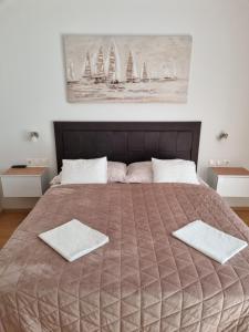 a bedroom with a large bed with two towels on it at Apartmani BELVEDERE in Brela