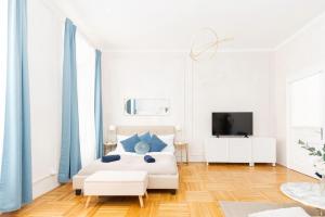 um quarto branco com uma cama e uma televisão em Spacious and Near Metro, Perfect for Groups of 14 em Viena