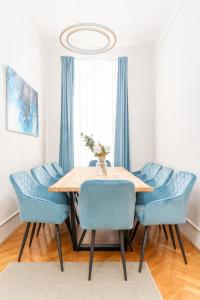 a dining room with a table and blue chairs at Spacious and Near Metro, Perfect for Groups of 14 in Vienna