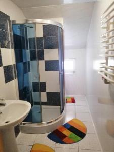 La salle de bains est pourvue d'une douche et d'un lavabo. dans l'établissement Садиба Криниченька, à Yaremtche