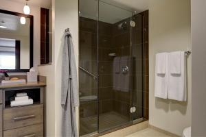 W łazience znajduje się prysznic ze szklanymi drzwiami. w obiekcie Hyatt House Sacramento Airport - Natomas w mieście Sacramento