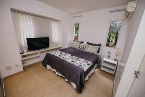 a bedroom with a bed and a flat screen tv at Beach House Sauípe in Costa do Sauipe