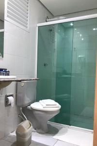 a bathroom with a toilet and a glass shower at Riviera de São Lourenço - 302 Amarilis in Bertioga