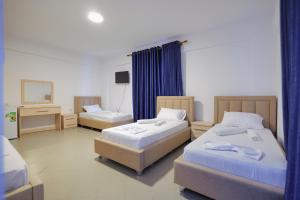 Habitación de hotel con 2 camas y TV en Mema Hotel en Himare