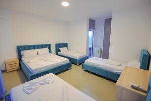 Habitación con 2 camas y mesa. en Mema Hotel en Himare