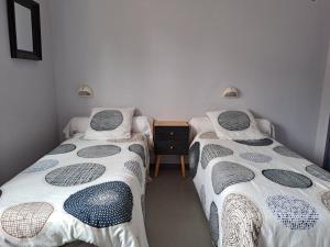 a room with two beds and a table in it at LA VILLA DU CAP in Cap-Ferret