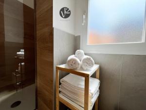 a bathroom with towels on a shelf next to a shower at V12 Apartments Puglia Modugno in Modugno +18 photos