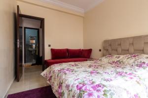 1 dormitorio con 1 cama y 1 sofá rojo en App GH7, en Agadir