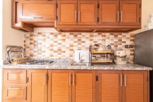 een keuken met houten kasten en een aanrechtblad bij Al-Sabah Residence Agadir in Agadir