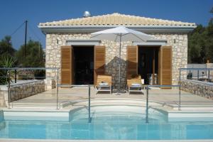 a house with a swimming pool with an umbrella at Sunkiss Private Retreat Cottage With Pool in Sivota