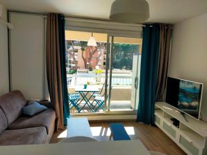 a living room with a couch and a large window at leflamantduport in Hyères
