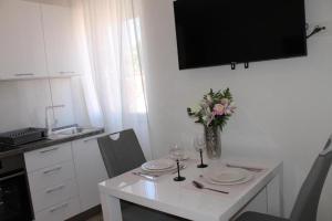 扎達爾的住宿－Jeta 2 studio & rooms，厨房配有白色的桌子和花瓶