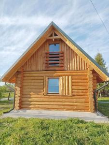 Cabaña de madera con ventana en la parte superior en Drewniany Domek Małgorzatka, 