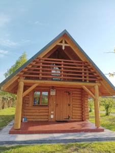 una cabaña de madera con techo de gambrel en Drewniany Domek Małgorzatka, 