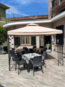 patio con tavolo e sedie sotto un grande ombrellone di Residence Paradiso Bilocale 203 a Moneglia Altre 2 foto