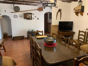 a dining room with a wooden table and chairs at Casas Rurales Cortijo Cerro Fuentes Nuevas in Castril