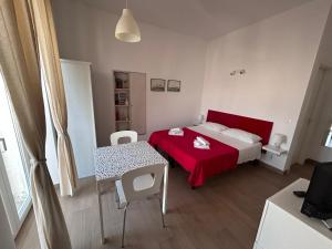 una camera con letto rosso e tavolo di Casa Petrolla 126 a Villanova