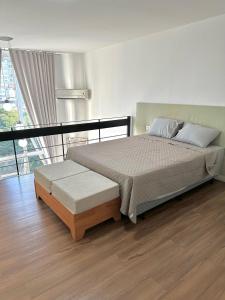 Schlafzimmer mit einem Bett und Holzboden in der Unterkunft Saint Sebastian Flat 307 - Com Hidro! até 4 pessoas, Duplex, no centro in Jaraguá do Sul