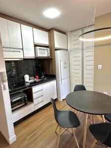 a kitchen with a table and chairs and a refrigerator at Saint Sebastian Flat 307 - Com Hidro! até 3 pessoas, Duplex, no centro in Jaraguá do Sul +12 photos