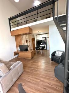 ein Wohnzimmer mit einem Sofa und einem Loft in der Unterkunft Saint Sebastian Flat 307 - Com Hidro! até 4 pessoas, Duplex, no centro in Jaraguá do Sul