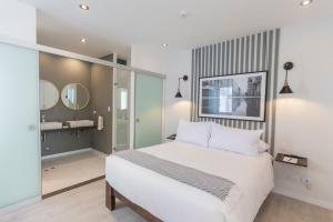 a bedroom with a large white bed and a bathroom at Monochromatic 2BR in Miraflores in Lima