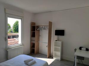 een witte slaapkamer met een bed en een raam bij Venise - Maison avec extérieur à Reims in Reims