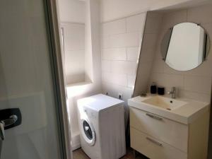 a small bathroom with a washing machine and a sink at Venise - Maison avec extérieur à Reims in Reims