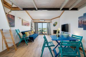 un soggiorno con tavolo e sedie blu di BmyGuest - Quinta do Lago Terrace Apartment I a Quinta do Lago