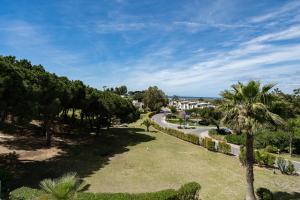 a park with palm trees and a road at BmyGuest - Quinta do Lago Terrace Apartment I in Quinta do Lago