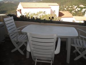 d'une table et de chaises blanches sur un balcon. dans l'établissement Les Emeraudes, à La Croix-Valmer