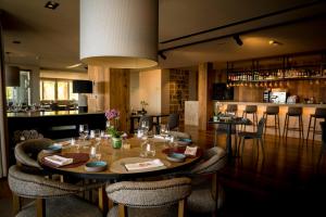 a dining room with a table and chairs and a bar at Los Jardines de Abama Suites in Guía de Isora