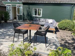 a patio with a table and chairs and a couch at appartement Elperhof 16B in Schoonloo